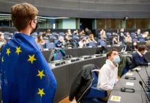 The EYP History Book is Now Available A guy with the Union Europe's flag standing at the European Youth Parlament